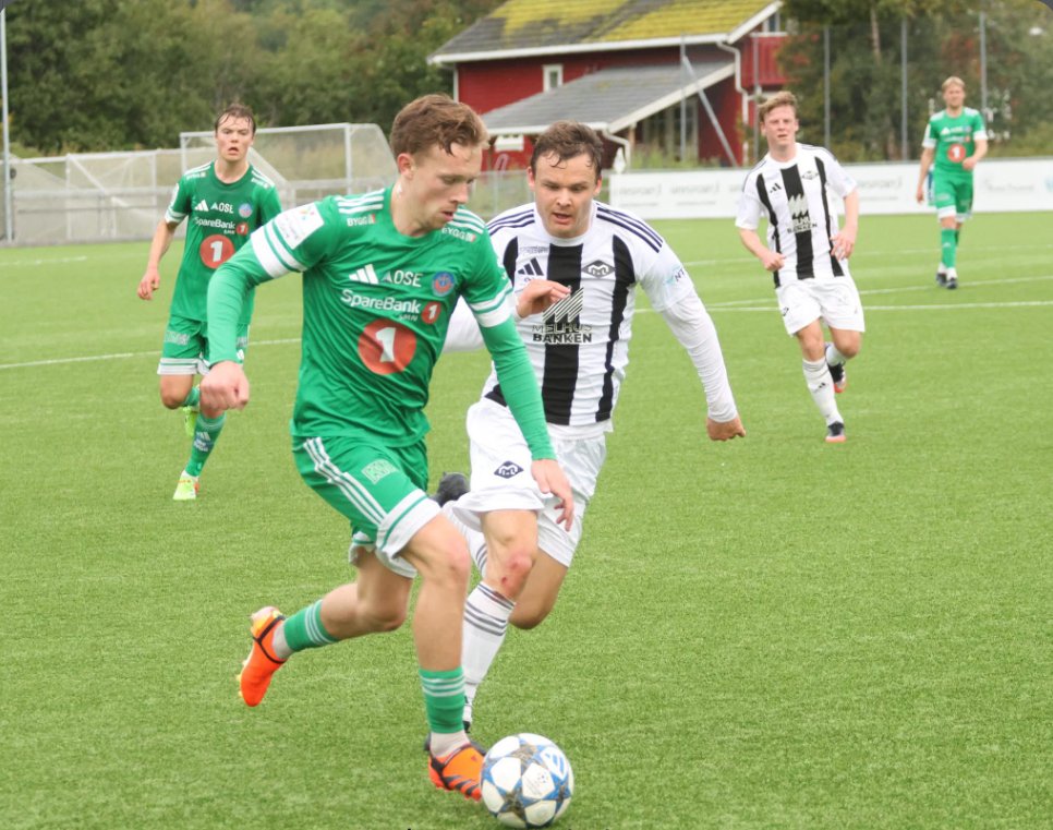 Player in green dribbling past a defender